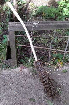 a broom sitting on the ground next to a fence