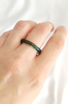 Explore the enchanting allure of handmade emerald green ring, crafted with durable borosilicate glass. The emerald green color full of energy will bring extra WOW to your outfit! Due to its artisanal shaping, the surface of the ring may exhibit slight irregularities, adding to its unique charm. Depending on the type and intensity of light, the ring showcases shades of green ranging from emerald to vibrant or subtly muted tones with a hint of gray. This bit of magic enclosed in glass will add uniqueness to your jewelry collection. Elevate your style with this captivating piece that captures the essence of nature's elegance. Each ring is a one-of-a-kind creation, ensuring you adorn a truly distinctive accessory. All the products are packed safely in the beautiful paper box and will be a perf Emerald Green Ring, Nature Inspired Rings, Green Ring, Green Rings, Glass Ring, Minimalist Gifts, Muted Tones, Color Full, Glass Rings