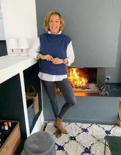 a woman standing in front of a fire place