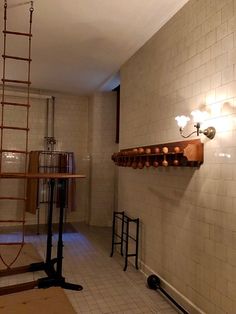 a bathroom with white tiled walls and ladders hanging from the wall next to it