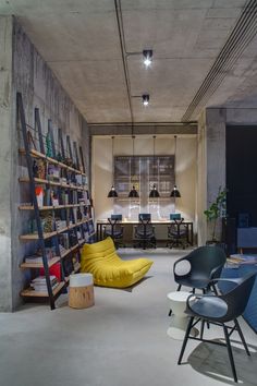 a room with several chairs and shelves filled with books