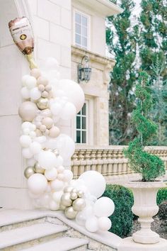 white balloons are hanging from the side of a building