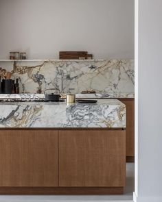 a kitchen with marble counter tops and wooden cabinets