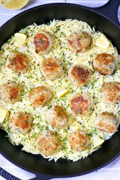 a skillet filled with pasta and meatballs on top of a white table cloth