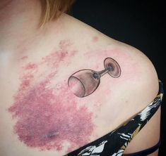 a woman's chest with pink ink on it and a piece of glass in the middle