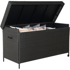 an outdoor wicker storage box with lid open and papers in the bottom compartment, on a white background