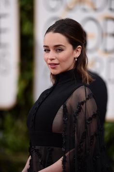 the actress is wearing a sheer black dress and posing in front of an oscars red carpet