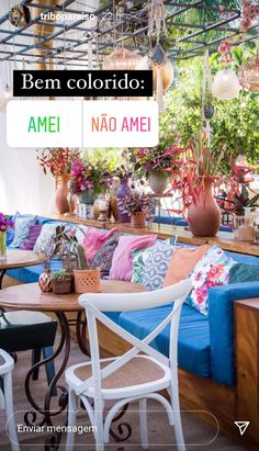 the interior of an outdoor restaurant with colorful furniture and flowers on the tables in front of it