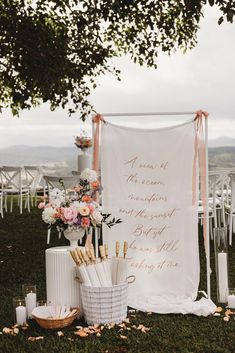 an outdoor ceremony setup with flowers, candles and a sign that says i know the name of the ceremony