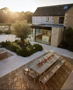 a wooden table sitting on top of a patio next to a tree and grass covered field