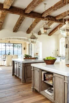 a large kitchen with an island in the middle and lots of wood beams on the ceiling