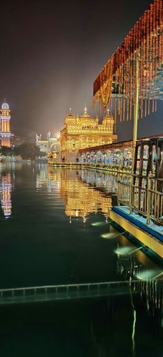 the lights shine brightly in the night sky over the water and buildings on either side