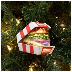 a christmas ornament shaped like a box with a sandwich in it hanging from a tree