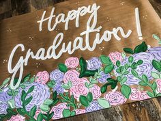 a sign that says happy graduation with flowers on it