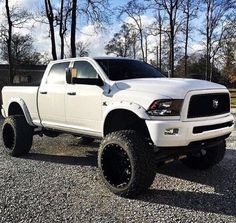 a white truck is parked in the gravel