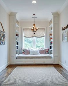 a window seat in the corner of a room with built - in bookshelves