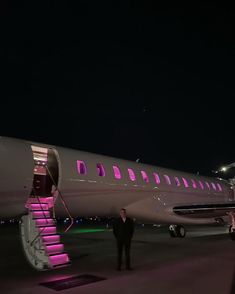 a large jetliner sitting on top of an airport tarmac next to a stairway