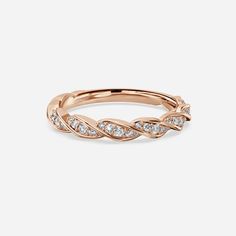 a rose gold ring with white diamonds on the sides and a twist design in the middle