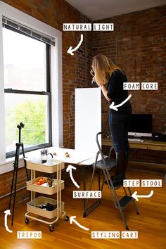 a woman standing in front of a window next to a whiteboard and easel