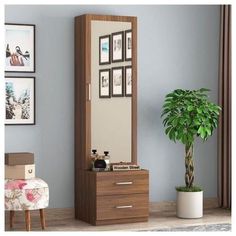 a mirror sitting on top of a wooden dresser next to a potted green plant