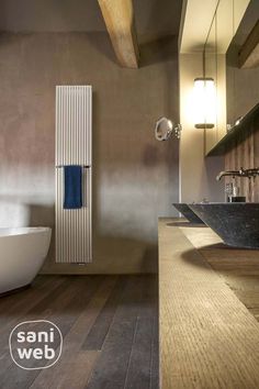 a bathroom with a tub, sink and towel rack in the middle of the room