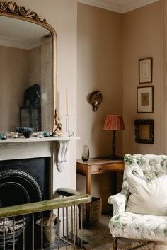 a living room filled with furniture and a fire place in front of a large mirror