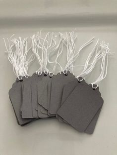 six tags with white string attached to them