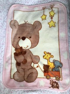 a baby blanket with a teddy bear and giraffes on it's side