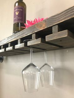 two wine glasses are hanging from a shelf