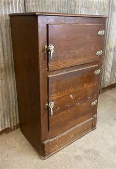 an old wooden cabinet sitting in front of a wall