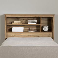 a bed with a wooden headboard and shelf above it