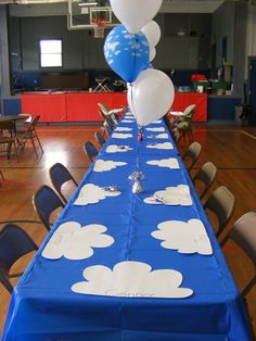 a blue table with white clouds on it and a balloon in the air at the top