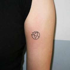 a woman with a small tattoo on her arm that has the earth and arrows in it