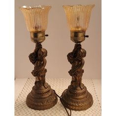 a pair of antique brass candlesticks with glass shades