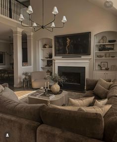 a living room filled with furniture and a fire place under a chandelier in front of a fireplace