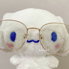 a white teddy bear wearing glasses with blue eyes