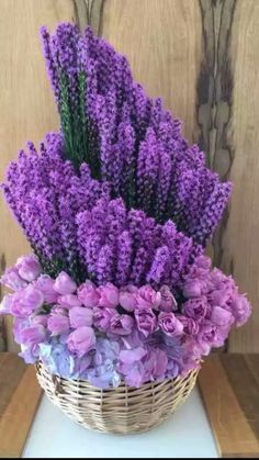 a basket filled with purple flowers sitting on top of a table