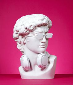 a mannequin wearing headphones against a pink background