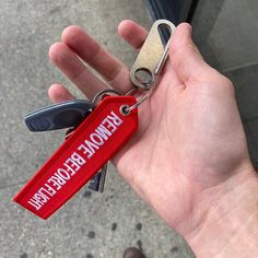 a hand holding a red keychain with the name ramon becken on it