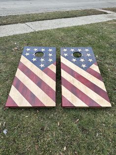 two american flag cornhole boards laying on the grass