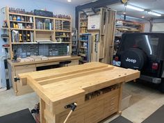 a workbench in a garage with tools on the table and shelves behind it