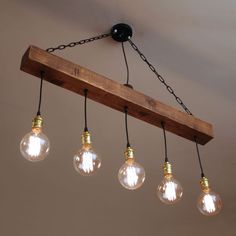 five light bulbs hanging from a wooden beam