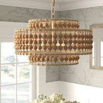 a chandelier hanging from the ceiling in a dining room with white walls and windows