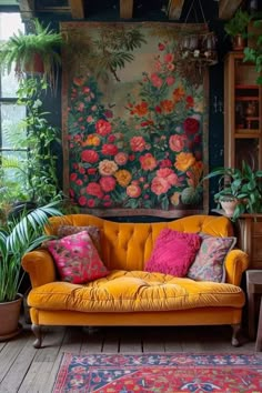 an orange couch in front of a painting and potted plants