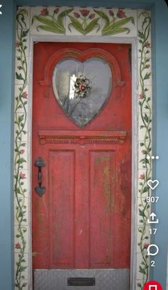 a red door with a heart shaped mirror on it