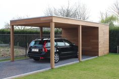 a black car parked in front of a wooden carport