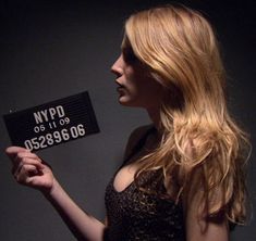 a woman holding up a sign that reads nypd 60, 699, 898, 986