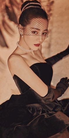 a woman wearing a black dress and gloves