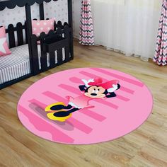 a minnie mouse rug on the floor in a child's room with pink and black decor