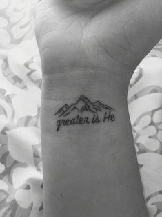 a small wrist tattoo with the words greater is he